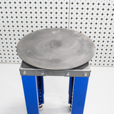 steel workbench with silver turntable on top, on a white patterned background